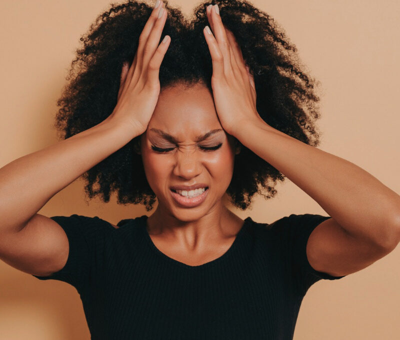 Frustrated woman standing with her hands on her head