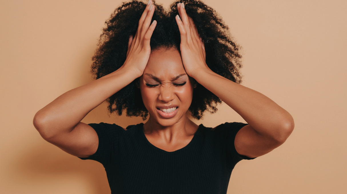 Frustrated woman standing with her hands on her head