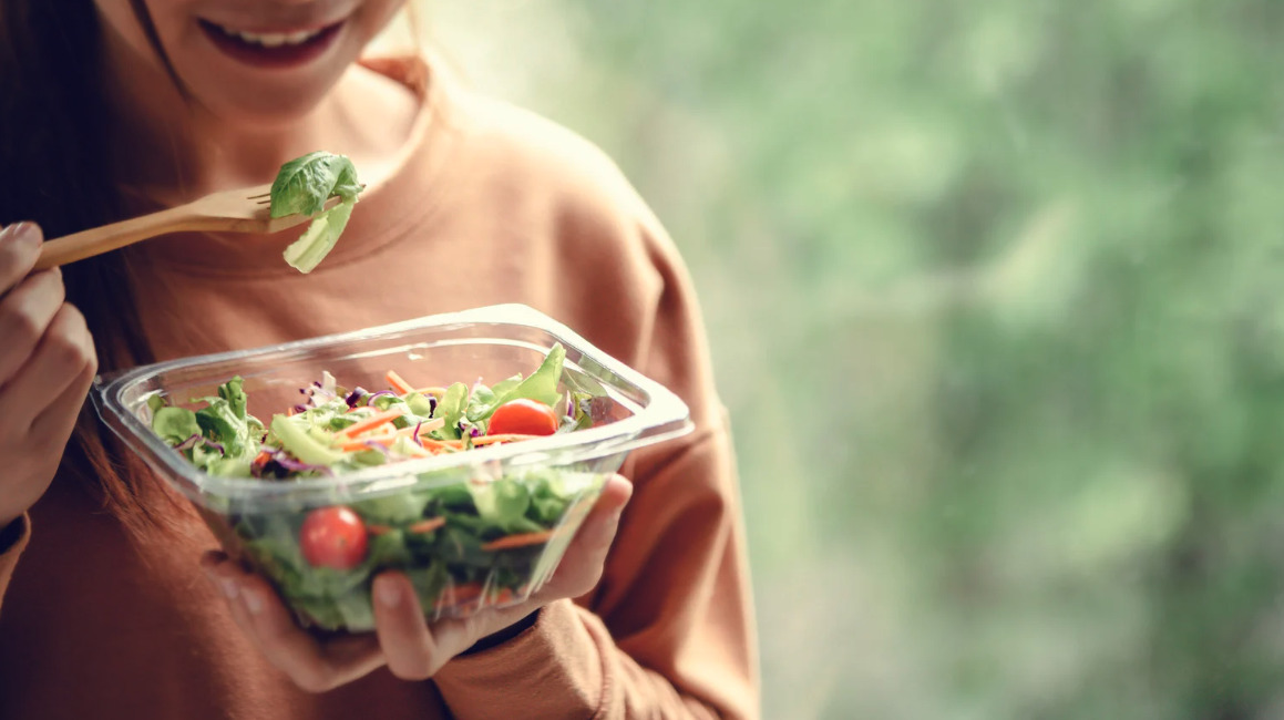 Woman eating a healthy salad from a bowl