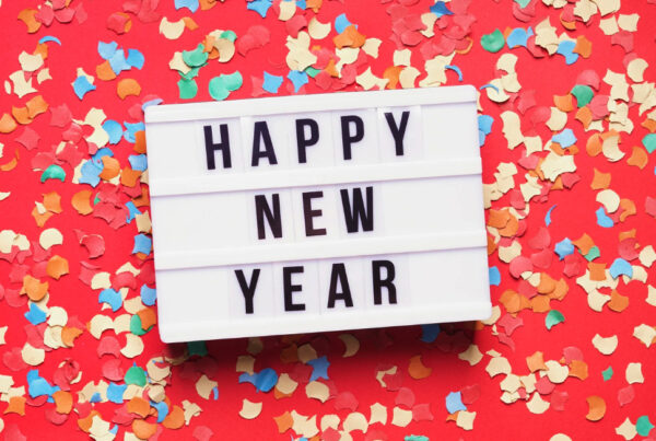 A Happy New Year light box sign on a red background
