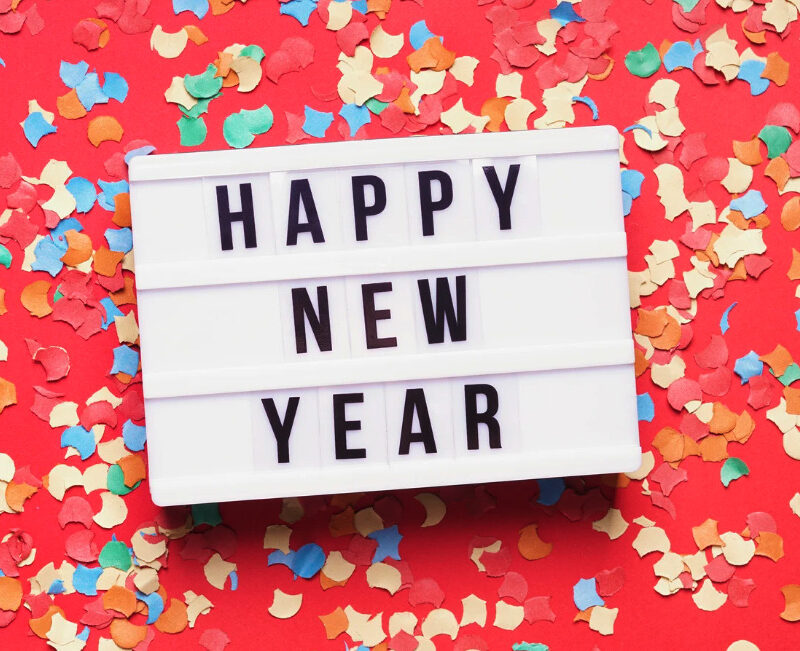 A Happy New Year light box sign on a red background