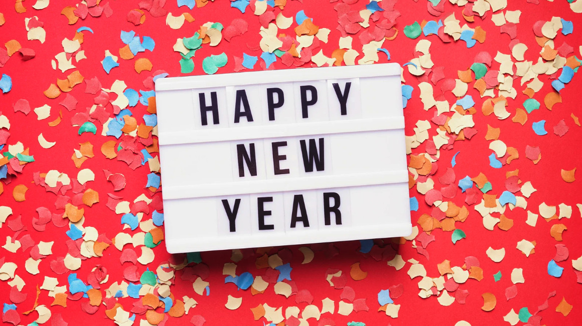 A Happy New Year light box sign on a red background