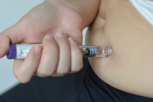 Woman injecting a GLP-1 weight loss medication into her abdomen