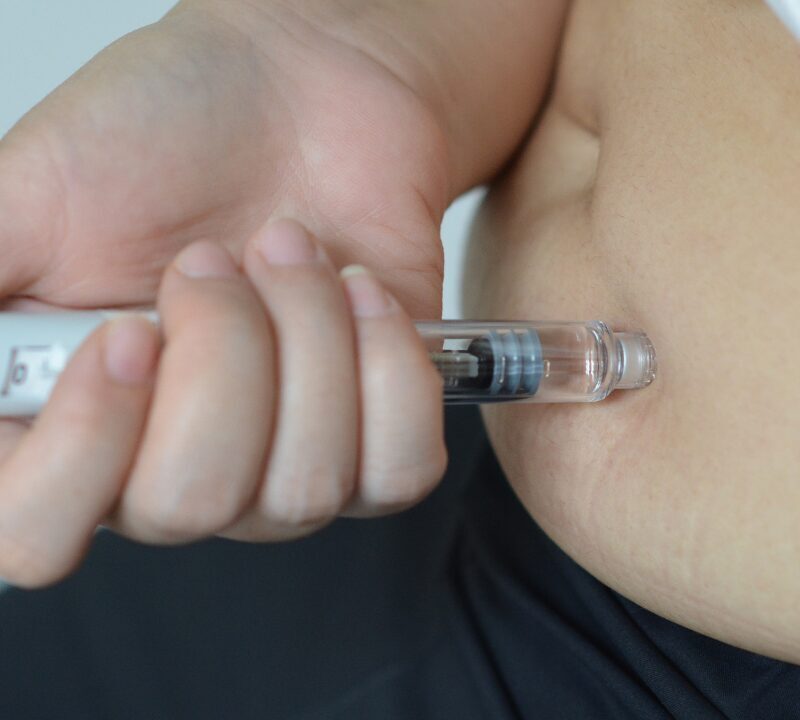 Woman injecting a GLP-1 weight loss medication into her abdomen